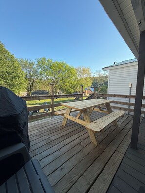 A wooden deck with a picnic table, a grill, and a covered area. - 9 min to Windrock/12 min to Oak Ridge-Sleeps 6+/2 car garage/Full Laundry (Oliver Springs)