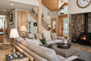 A cozy living room with a fireplace, a sofa set, a lamp, and a staircase. - Black Butte Ranch South Meadow 145 (Black Butte Ranch)