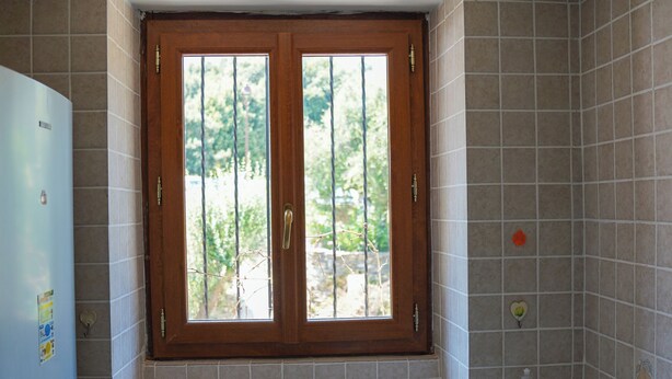 A kitchen with a window, sink, and a refrigerator.