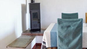 A room with a fireplace, a table with chairs, and a tiled floor.