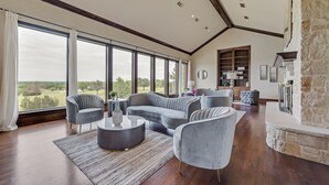 Un salon spacieux doté d’une grande fenêtre, d’une cheminée et d’une bibliothèque intégrée.