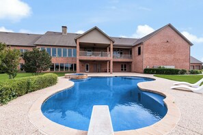A large swimming pool with a two-story building in the background.