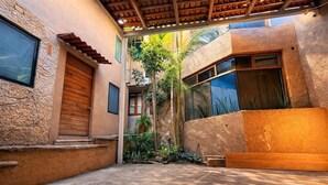 A courtyard with a wooden door, a window, and a wall with a textured surface. - suite privada, zona consulado (Zapopan)