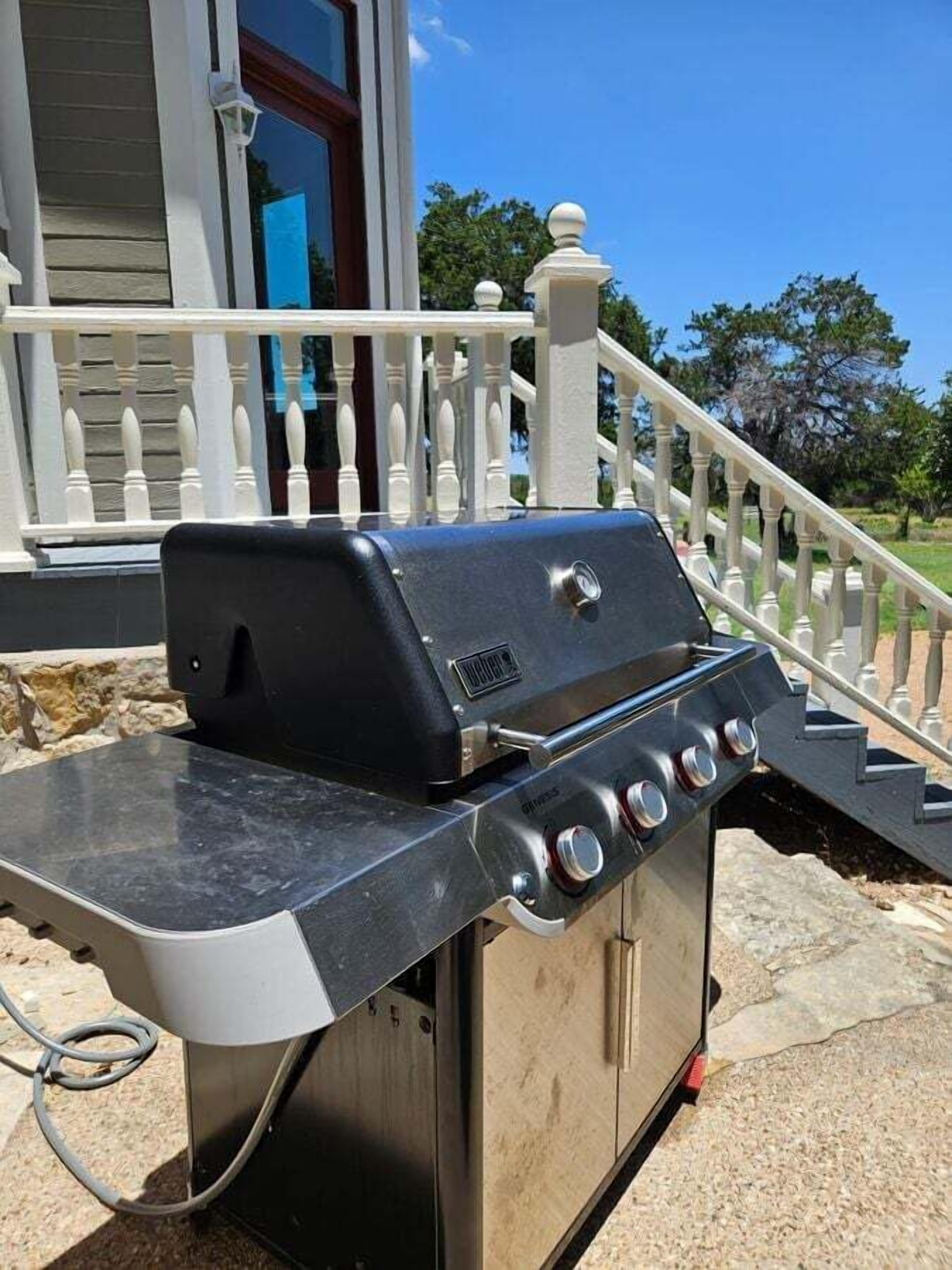 A barbecue grill with a control panel, a power cord, and a metal cabinet.