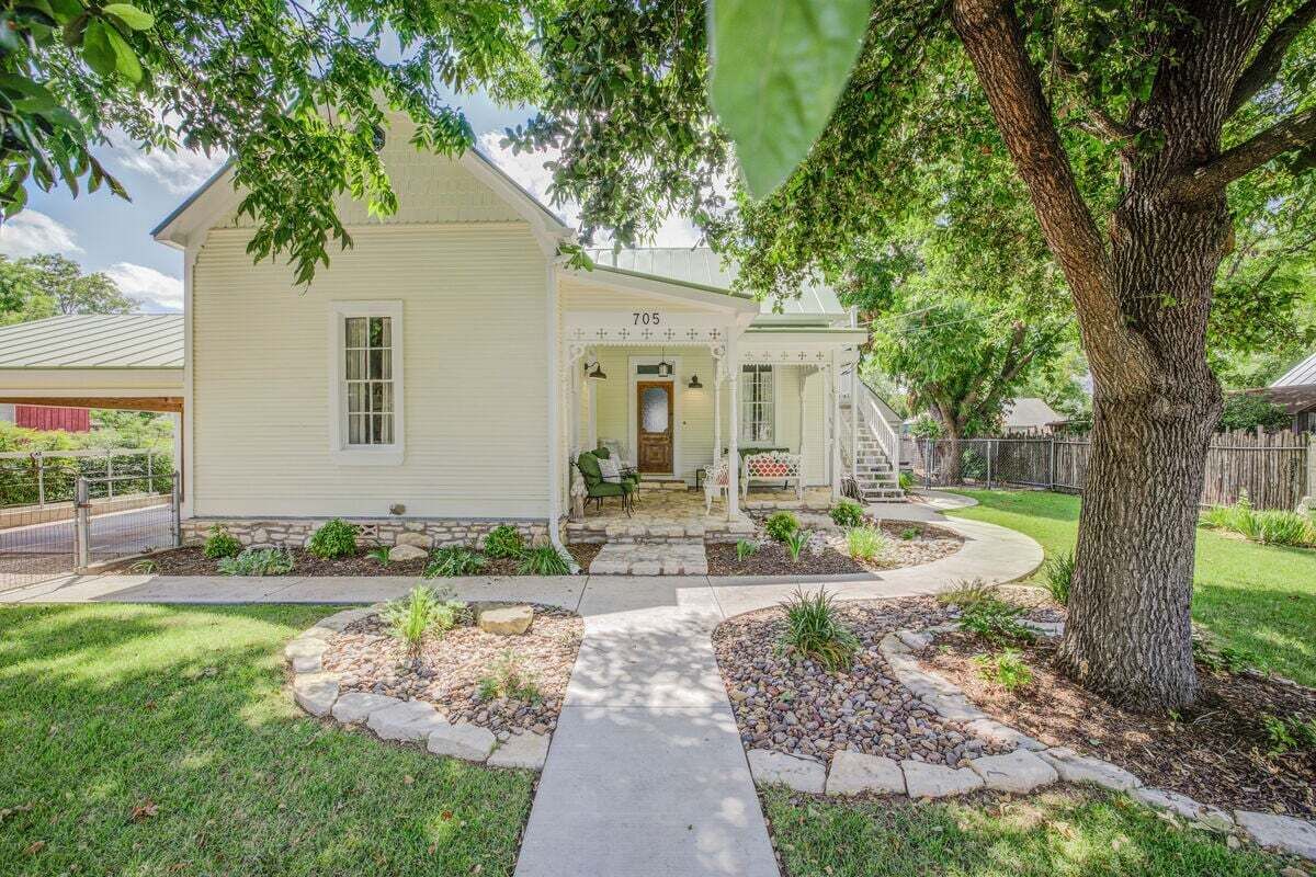 A single-story house with a front porch, a mailbox, and a number '705' on the door.