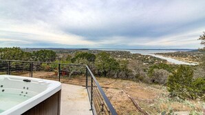 Uma banheira de hidromassagem em uma varanda com vista para o rio e a paisagem.
