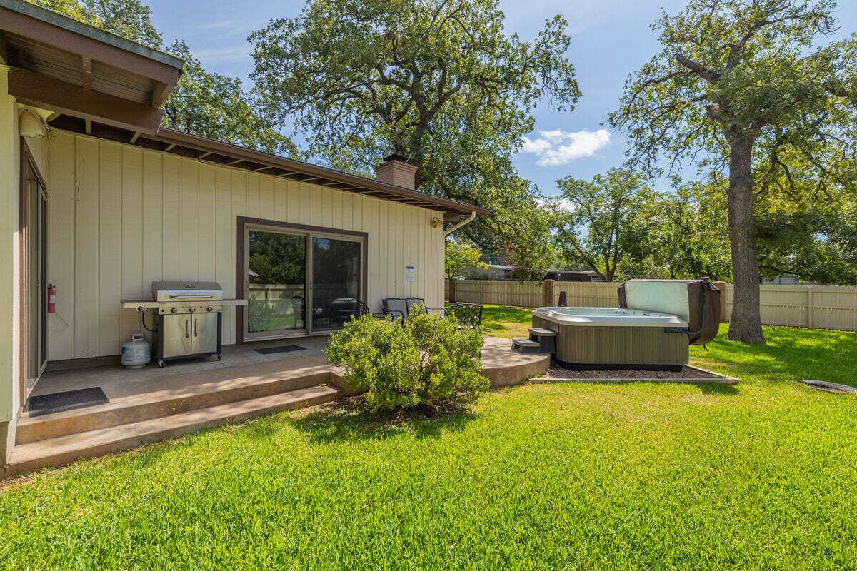 Una casa con patio, jacuzzi y parrilla.