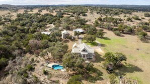 An aerial view of a property with a large house, a swimming pool, and surrounding trees. - Unique Victorian Estate Pets Welcome Pool BBQ Picnic Privacy (Dripping Springs)