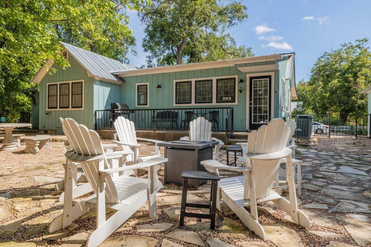 A house with a porch, outdoor seating, and a grill.