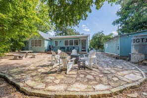 A house with a stone patio, outdoor seating, and a small deck. - Town Creek Haus - Close to Wineries and Main! (Fredericksburg)