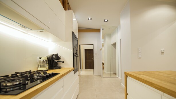 Una cocina moderna con estufa a gas, cafetera y encimeras de madera.