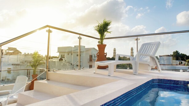 A rooftop pool area with a glass balustrade, white lounge chairs, and a potted plant. - Casa Rama 2. 2 bedroom, 2 bathroom w/ private pool in Cozumel (Cozumel)