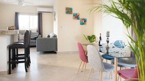 A modern living room with a dining area, featuring a ceiling fan, a sofa, a coffee table, and a dining table set for six. - Casa Rama 2. 2 bedroom, 2 bathroom w/ private pool in Cozumel (Cozumel)