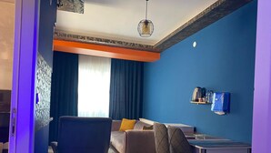 Una sala de estar moderna con un sofá, una mesa de comedor y un televisor.