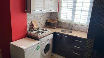 Apartamento Deluxe, balcón | Cocina privada | Frigorífico pequeño, microondas, horno y placa de cocina
