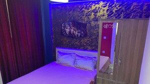 Una habitación con cama, armario y un panel decorativo en la pared.