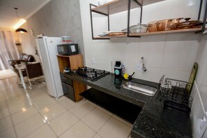 Una cucina moderna con piano cottura a gas, forno a microonde e macchina del caffè.