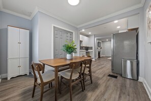A kitchen with a wooden table and chairs, a refrigerator, and a potted plant. - 3BR West End Home w/ Deck & Large Backyard (Atlanta)