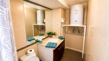 Departamento estándar, balcón | Baño | Tina con regadera, secadora de cabello, toallas, jabón