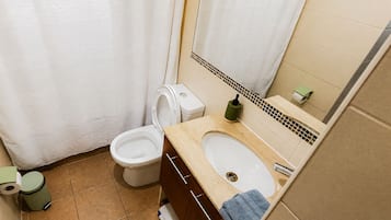 Ein Badezimmer mit Toilette, Bidet, Waschbecken und Spiegel.