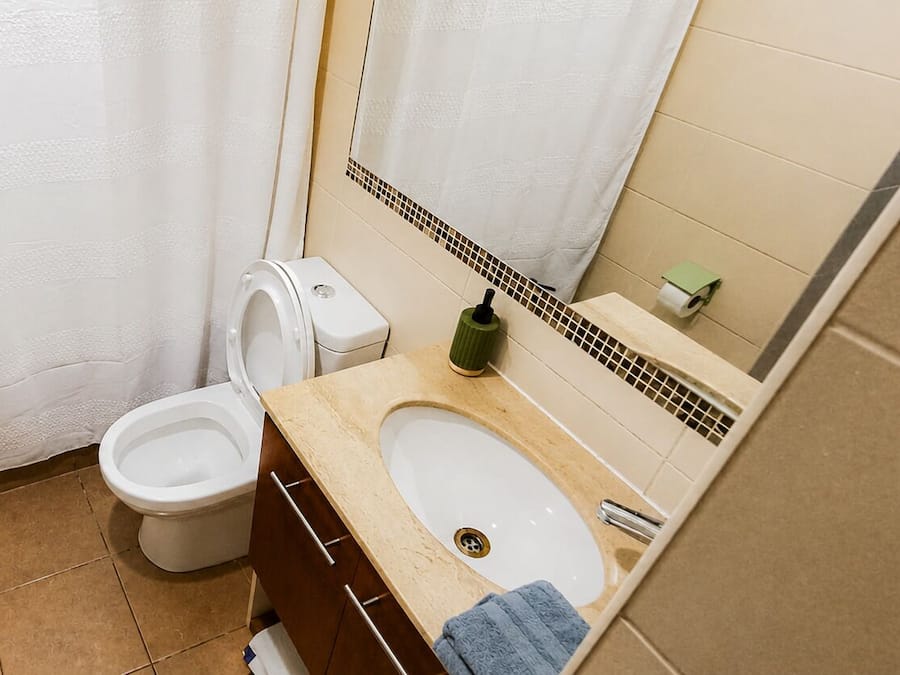 Ein Badezimmer mit Toilette, Bidet, Waschbecken und Spiegel.