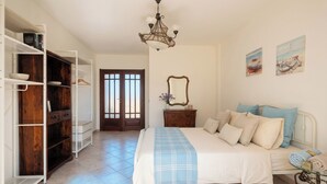 A bedroom with a bed, a dresser, a wardrobe, a chandelier, and artwork on the walls. - ClickSardegna Villa Garden in Alghero for 10 Guests with Garden (Alghero)
