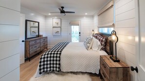 A bedroom with a bed, a dresser, a mirror, and a ceiling fan. - LAKEFRONT PROPERTY l DANCING BEAR (Lake Toxaway)