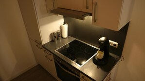 Een keuken met een fornuis, oven en koffiezetapparaat.