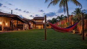 A residential area with a house, a hammock, and a palm tree. - Rancho da Vó Vera | Recém Reformado e Bem Equipado (Bariri)