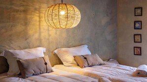 A hotel room with two beds, a woven light fixture, and framed artwork on the wall. - Rancho da Vó Vera | Recém Reformado e Bem Equipado (Bariri)