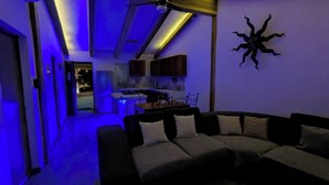 Un salon moderne avec un canapé et une cuisine en arrière-plan.