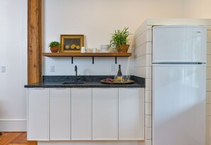 Fridge, microwave, coffee/tea maker, cookware/dishes/utensils