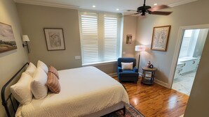A bedroom with a bed, a chair, a lamp, and a rug. - Marymount College Building (Salina)