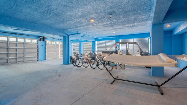 A spacious room with a large bed, a treadmill, and multiple bicycles. - Shore Bet (Fort Myers Beach)