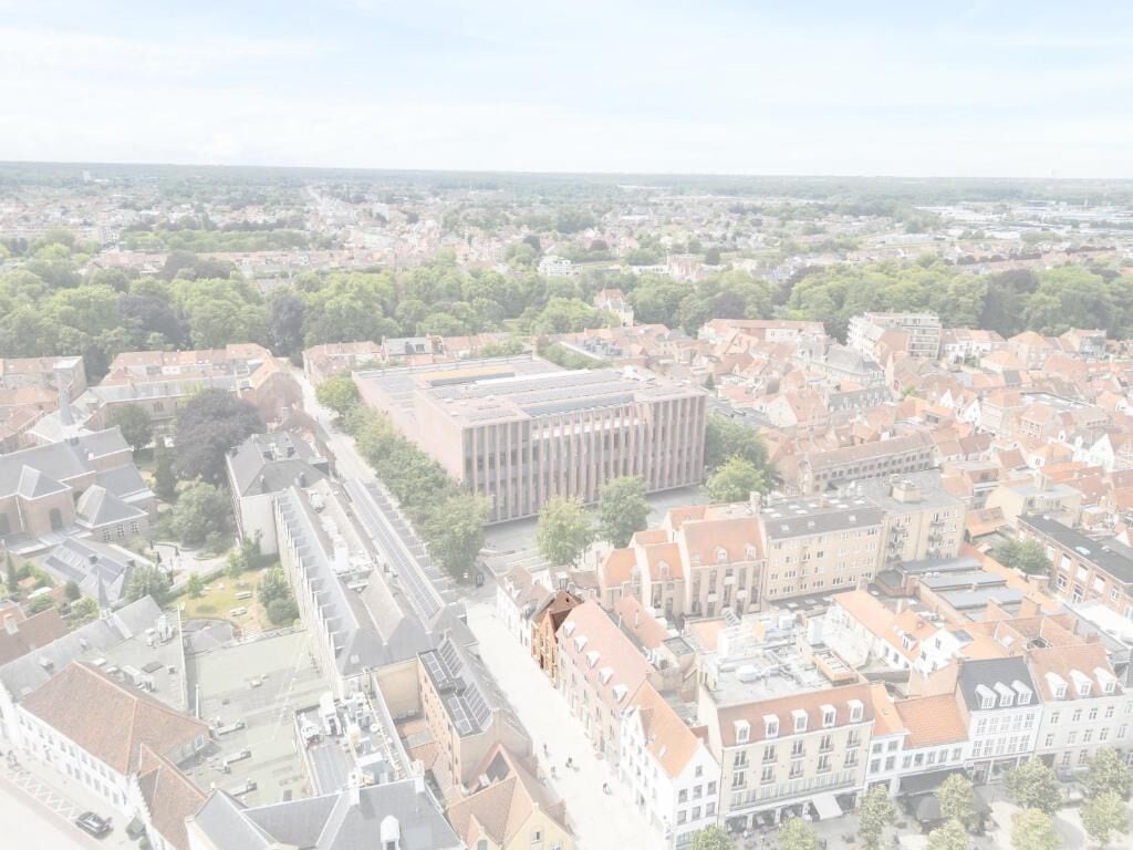 Luchtbeeld van een stadsgezicht, met een opvallend gebouw met een moderne gevel, omringd door traditionele architectuur.