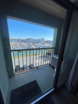 A balcony with a view of a parking lot and buildings. - Cute 1-bedroom apt 23rd St in Ocean City near the beach (Ocean City)