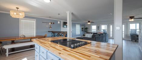 Una cocina amplia con una isla de madera, electrodomésticos integrados y un comedor con banco.