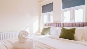A hotel room with a bed, a window, and a radiator. - Contractor and Business Stays | Sleeps 6 | WiFi (Hertfordshire)