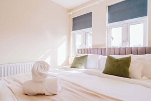 A hotel room with a bed, a window, and a radiator.