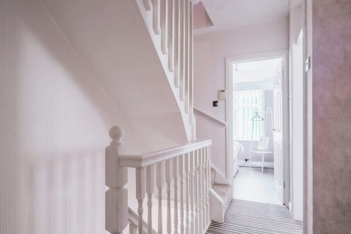 A staircase leading to a room with a white door, a small table, and a chair.
