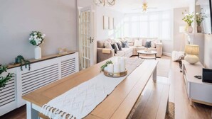 Ein modernes Wohnzimmer mit einem Holzesstisch, einer Sofagarnitur und einer Chandeliebre.
