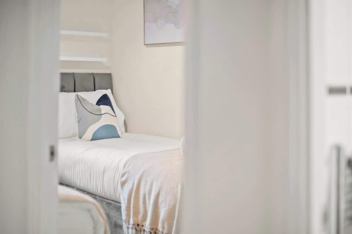 A bedroom with a bed, a headboard, and a wall-mounted artwork.