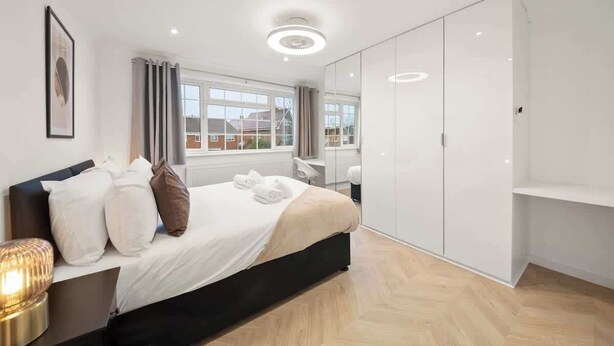 Une chambre à coucher moderne avec un lit, une table de chevet et une armoire.