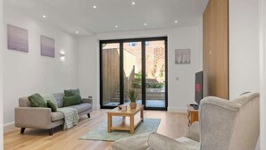 Un salon moderne avec un canapé, une table basse et un téléviseur.