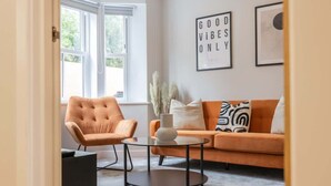 Un salon avec un canapé, un fauteuil et une table basse.