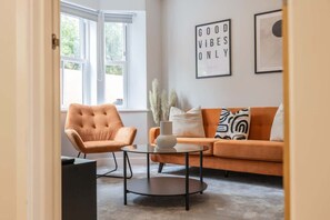 Ein Wohnzimmer mit Sofa, Sessel und Couchtisch.