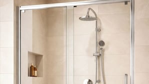 A glass-enclosed shower with a handheld showerhead and a wall-mounted faucet. - Modern Hotel Room In Historic Malthouse (Newport)