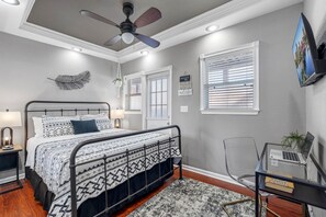 A bedroom with a bed, a desk, a chair, a ceiling fan, and a window with blinds. - Urban Retreat • Explore DTSP, Walk Everywhere! (St. Petersburg)
