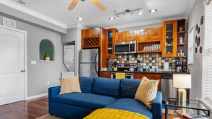 A modern kitchen with wooden cabinets, a microwave, and a stove. - Urban Retreat • Explore DTSP, Walk Everywhere! (St. Petersburg)