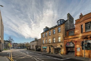 A street with buildings, a clear sky, and a traffic light.